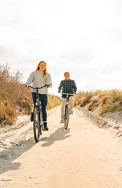 Mann und Frau radeln durch die Dünen auf Hiddensee