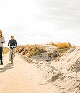 Mann und Frau radeln durch die Dünen auf Hiddensee