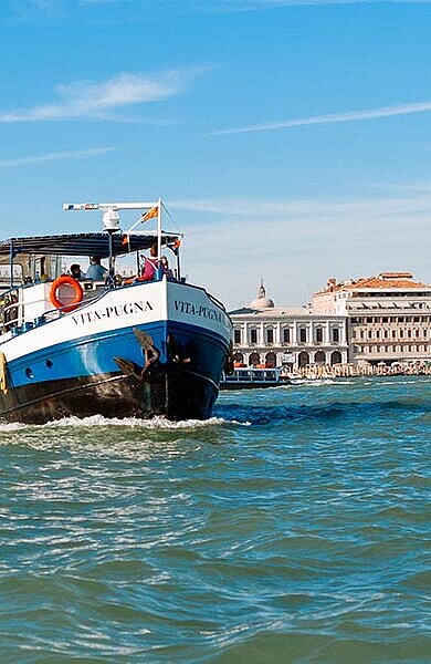 Schiff in Fahrt, im Hintergrund Venedig