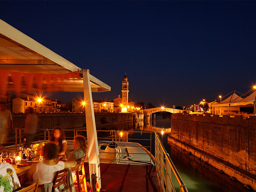 das Oberdeck des Schiffs, im Hintergrund das nächtliche Venedig