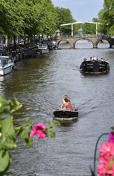 Blick von Brücke auf Kanal mit Booten in Amsterdam