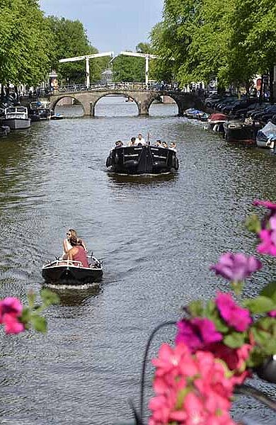 Blick von Brücke auf Kanal mit Booten in Amsterdam