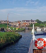 Ein Schiff fährt auf einem Fluss, im Hintergrund die Stadt Willemstad