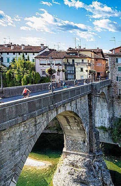 Radfahrer auf einer Brücke vor Udine