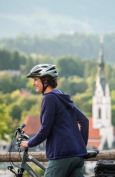 2 Radfahrer blicken auf den Kirchturm von Bad Tölz